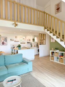 a living room with a blue couch and a kitchen at CASA ANPÀ Maison Vue Mer in Lecci