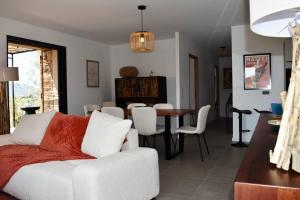 ein Wohnzimmer mit einem weißen Sofa und einem Esszimmer in der Unterkunft Amandula Bergerie Sotta hyper cozy in Sotta