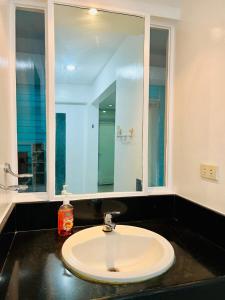 a bathroom with a sink and a mirror at Poolside Condo in Subic Bay in Olongapo +4 photos