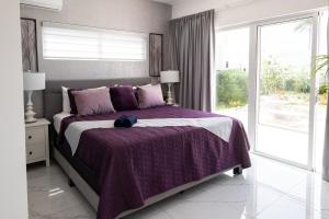 a bedroom with a bed with a purple blanket at Book Villa 1002 Luxury in Sosua in Sosúa +24 photos