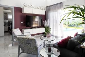 a living room with a couch and a tv at Book Villa 1002 Luxury in Sosua in Sosúa