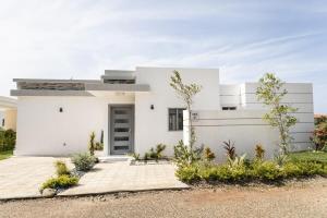 a white house with a driveway at Book Villa 1002 Luxury in Sosua in Sosúa