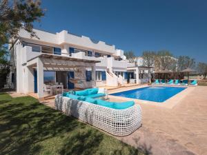 a villa with a swimming pool and some blue chairs at Domus A B 6 Pax in Portocolom