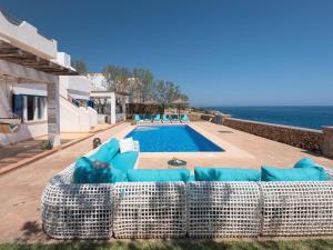a couch sitting next to a swimming pool at Domus A B 6 Pax in Portocolom
