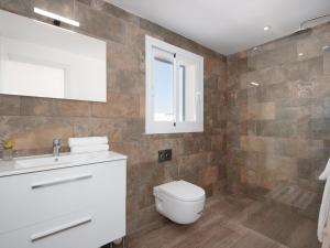a bathroom with a toilet and a sink and a window at Domus A B 6 Pax in Portocolom +32 photos