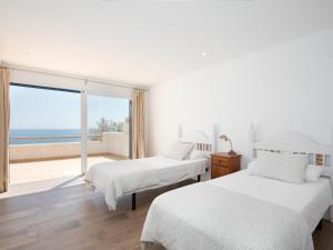 two beds in a room with a view of the ocean at Domus A B 6 Pax in Portocolom