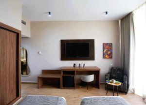 a living room with a desk and a tv at Rawabi Hotel Marrakech & Spa in Marrakesh