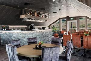 ein Restaurant mit Tischen und Stühlen und eine Bar in der Unterkunft Stor leilighet på Bualie, Golsfjellet in Gol