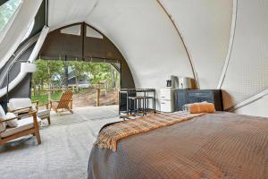 a bedroom with a bed in a tent at Escape to Cloud Nine Glamping in the Black Hills in Keystone