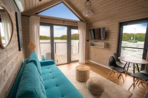 鲁恰内尼达Ruciane Park - Mazury resort & spa的客厅里有一张蓝色的沙发和一张桌子