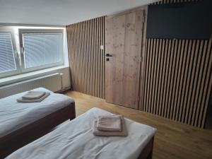 a bedroom with two beds and a door with two towels at Penzion DRUCKER in Čadca