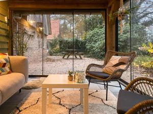un salon avec un canapé, des chaises et une table dans l'établissement Charming Decorated House in Nature, à Zuidwolde
