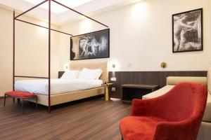 a hotel room with a bed and a chair at Hotel Vittoria in Pompei
