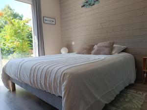 a bedroom with a large bed with a large window at Une escale gourmande- Suite avec terrasse & dîner maison possible in Eyzerac