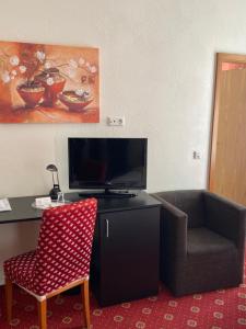 a room with a desk and a chair and a television at Hotel Bernkasteler Hof in Bernkastel-Kues
