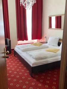 a bedroom with a large bed with red curtains at Hotel Bernkasteler Hof in Bernkastel-Kues