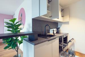 a kitchen with white cabinets and a potted plant at LeonArt Living 51 in Graz