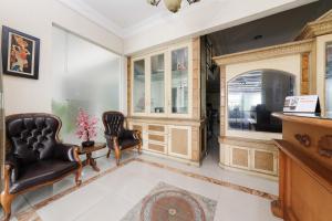 a living room with two chairs and a tv at RedDoorz at Jatiwaringin near Exit Toll Pondok Gede in Pangkalan