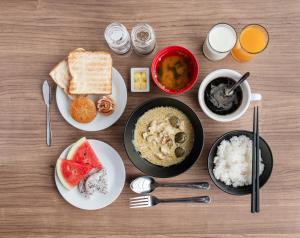 a table with plates of food and bowls of rice at Kokotel Rayong Beachfront in Ban Pak Khlong Phe