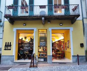 a store with a balcony on the side of a building at Alibi Bed and Beer Apartment in Ivrea