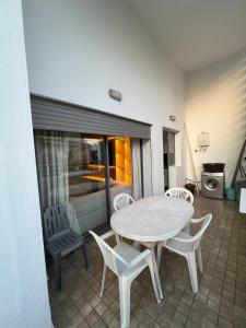 una mesa blanca y sillas en una habitación con cocina en Apartment in a residence, en Pont Blondin