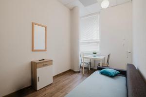 a room with a bed and a table with a mirror at Keja Rooms II - Pokoje Noclegi w Centrum Gdyni in Gdynia