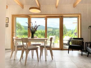 a dining room with a table and chairs and a window at Kořenov Serenity Heights in Kořenov