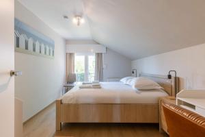 ein Schlafzimmer mit großem Bett und Fenster in der Unterkunft Huswell - Villa Near Beach with Double Parking in Oostduinkerke
