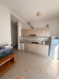 a large kitchen with a refrigerator and a counter at Райское место in Šušanj