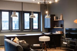 a living room with a couch and a kitchen with windows at Large Studio Apartment, Free Parking, Close to Centre in Southend-on-Sea