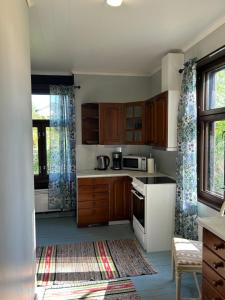 a kitchen with wooden cabinets and white appliances at Torppari in Kokkola