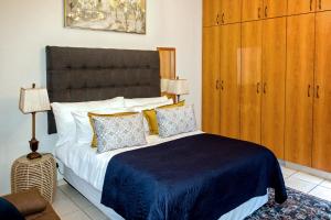 a bedroom with a large bed with a blue blanket at Windhoek self accommodation in Windhoek