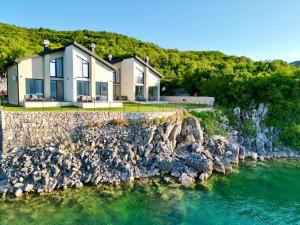 a house on the shore of a body of water at Salt Lake Villas in Nikšić