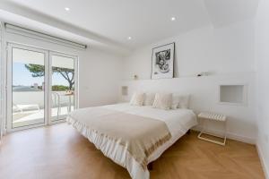 a white bedroom with a bed and a large window at Vale Do Lobo Resort in Vale do Lobo