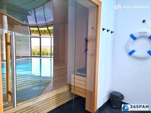 una puerta de cristal que conduce a una piscina en Westin House Rodzinny z 2 sypialniami - BASEN, JACUZZI, SAUNA, SALA FITNESS, PLAC ZABAW, PARKING W CENIE - 365PAM, en Kołobrzeg