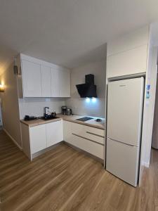 Una cocina con gabinetes blancos y un refrigerador. en El Rincón de Nicolás, en Arinaga