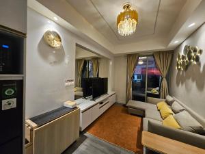 a living room with a couch and a tv at Apartemen Oakwood honolulu in Jakarta