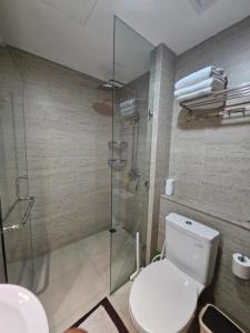 a bathroom with a toilet and a glass shower at Apartemen Oakwood honolulu in Jakarta