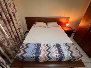 フリック・アン・フラックにあるResidence Les Peupliers 006のベッドスカート付きの小さな部屋のベッドspectspectspectssenalsenalsenal