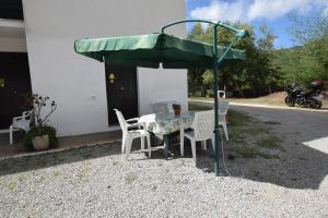 a table and chairs under a green umbrella at Bilocale Mancini 4 in Lacona
