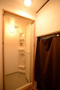 a bathroom with a glass door to a shower at Hakone Guesthouse Toi in Hakone