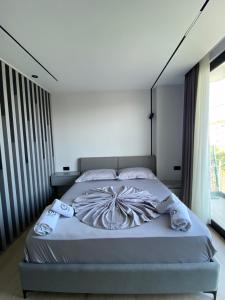 a bedroom with a large bed with white sheets at Hotel Bristol Velipoje in Velipojë