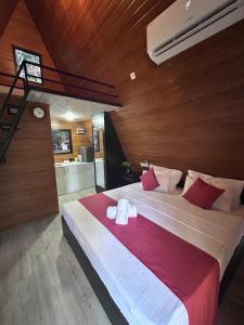 a bedroom with a large bed with red and white pillows at Greenwin Cabana Resort in Anuradhapura
