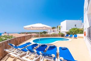 a swimming pool with lounge chairs and an umbrella at Villa Carolina in Alaior