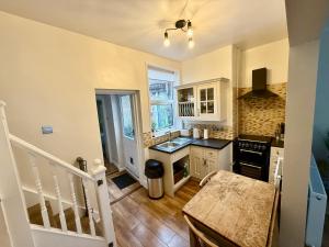 una cucina con mobili bianchi e pavimento in legno di The Market Nook - Beverley a Beverley