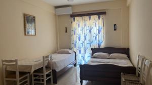 a room with two beds and a table and a window at Borsh Selavi Guest House in Borsh