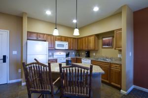 Una cocina con gabinetes de madera y un refrigerador blanco. en Wyndham Steamboat Springs 2BR Apartment with Resort Access, en Steamboat Springs 30 fotos más