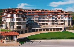 a large apartment building with a green lawn in front of it at Nikol Apart in Balchik