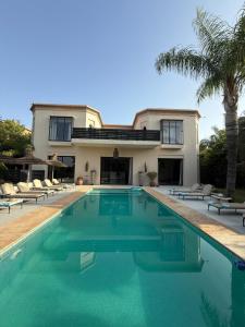a house with a swimming pool in front of a house at Villa Jude Luxury 6BR Villa with Private Pool, Sleeps 12, Near Golf & City in Marrakesh