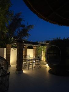 a patio with a table and chairs at night at Villa Jude Luxury 6BR Villa with Private Pool, Sleeps 12, Near Golf & City in Marrakesh +30 photos